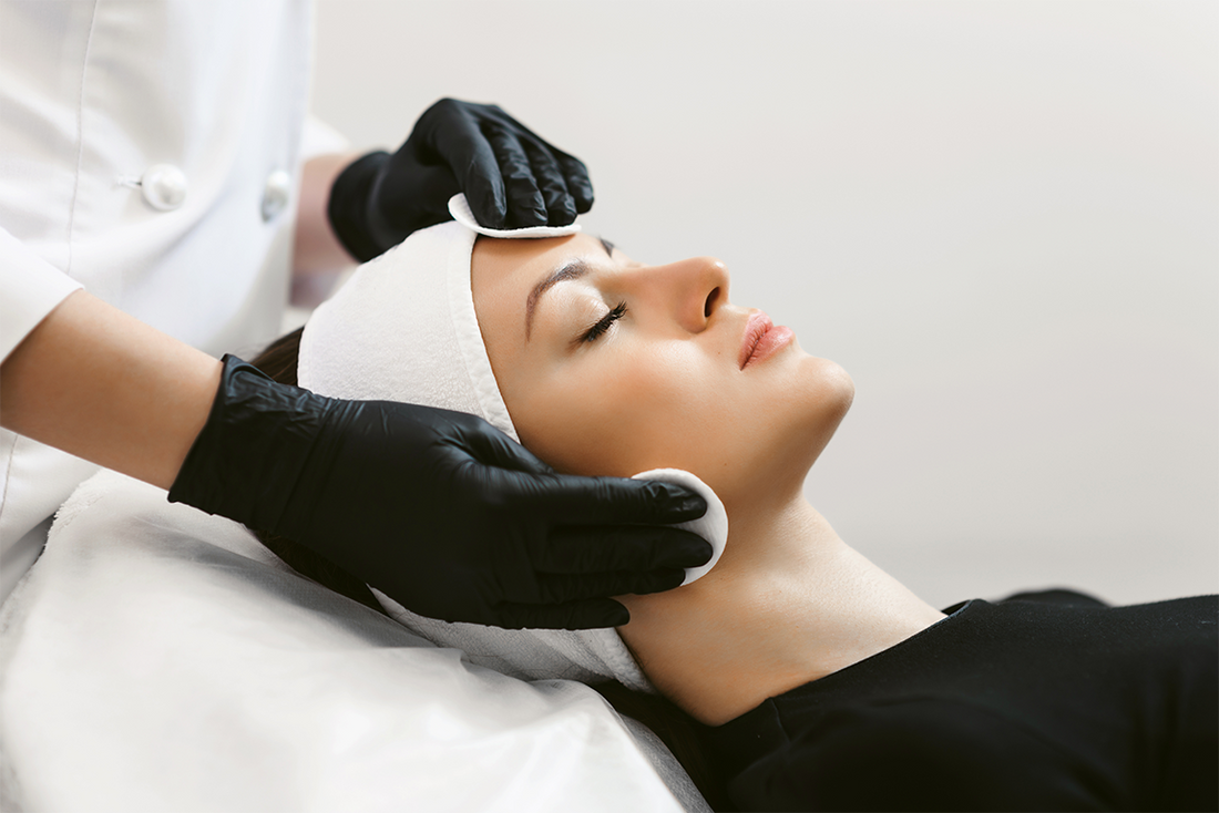 Image of a woman laid on beauty training bed getting facial treatment 